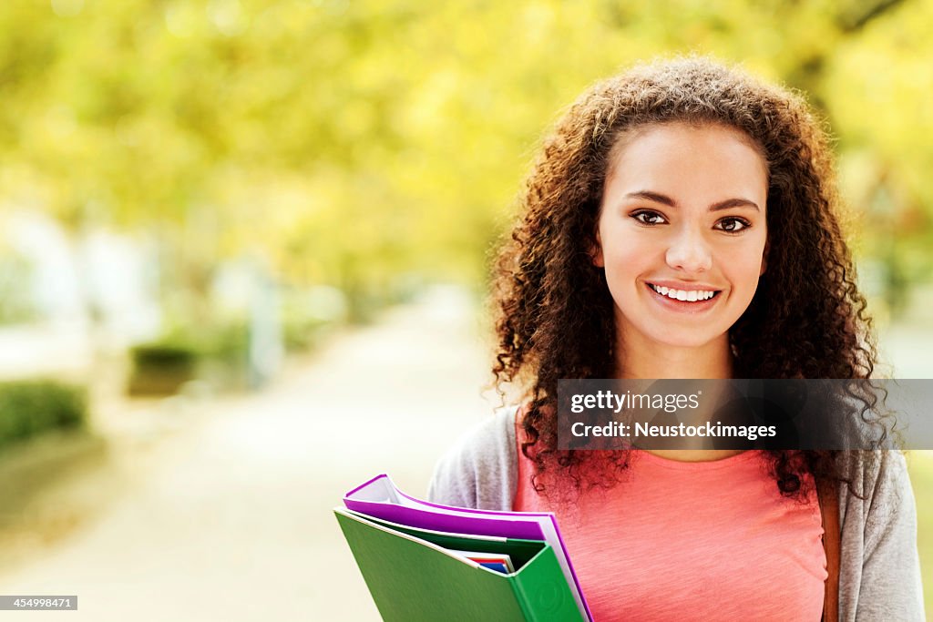 Beautiful Student With Ring Binders Smiling On Campus