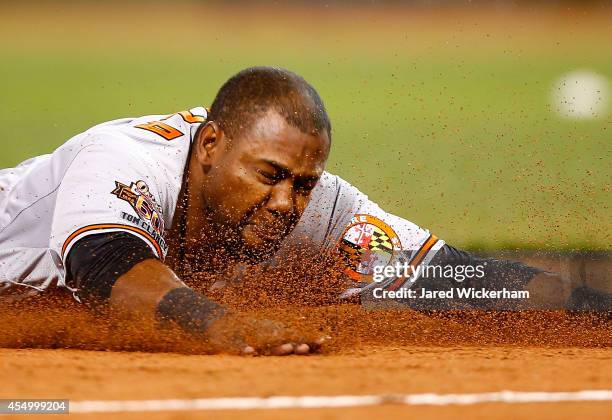 Alejandro De Aza of the Baltimore Orioles slides safely into third base against the Boston Red Sox during the game at Fenway Park on September 8,...