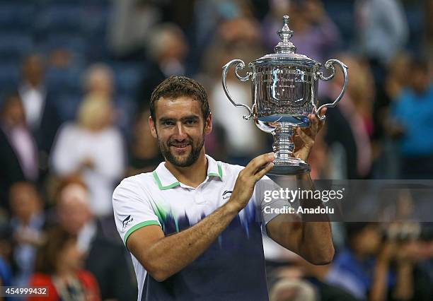 Marin Cilic of Croatia poses with the trophy after defeating Kei Nishikori of Japan to win the men's singles final match on Day 15 of the 2014 US...