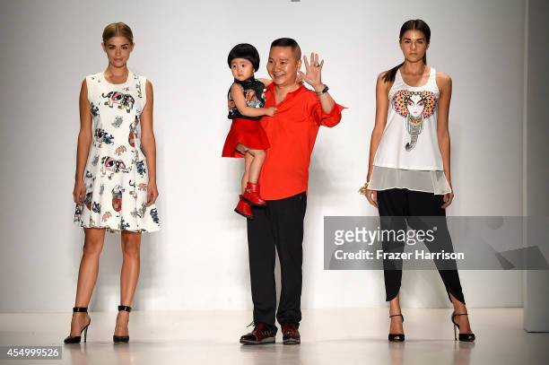 Designer Zhuliang Li appears on the runway with model Danielle Knudson and Miss Teen USA K. Lee Graham at the Oudifu fashion show during...