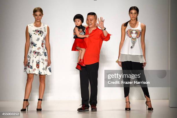 Designer Zhuliang Li appears on the runway with model Danielle Knudson and Miss Teen USA K. Lee Graham at the Oudifu fashion show during...