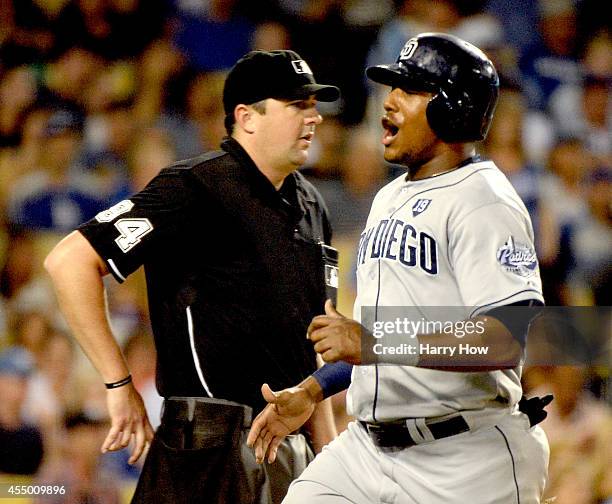 Rymer Liriano of the San Diego Padres reacts to his run in front of umpire Lance Barrett to trail 2-1 to the Los Angeles Dodgers during the fourth...