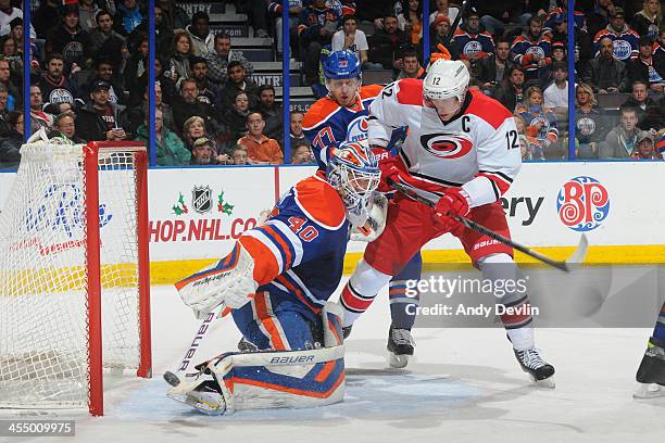 Devan Dubnyk of the Edmonton Oilers makes a save as Eric Staal of the Carolina Hurricanes skates in front of the net on December 10, 2013 at Rexall...