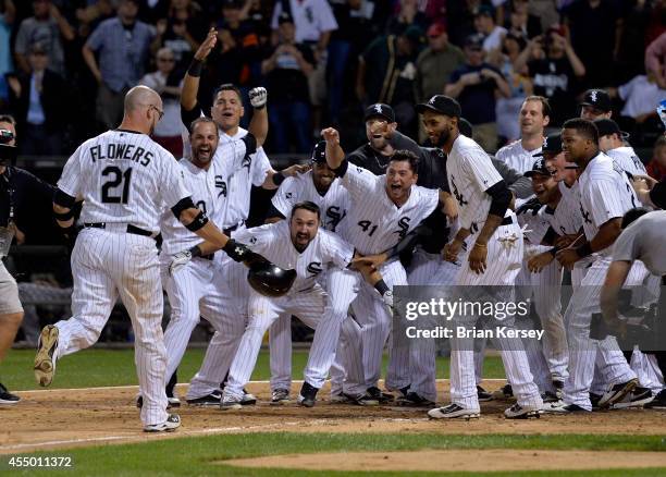 Tyler Flowers of the Chicago White Sox heads home as his teammates wait for him after he hit a game-winning solo home run during the twelfth inning...