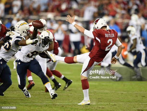 Punter Drew Butler of the Arizona Cardinals has his punt block by outside linebacker Jeremiah Attaochu of the San Diego Chargers in the second...