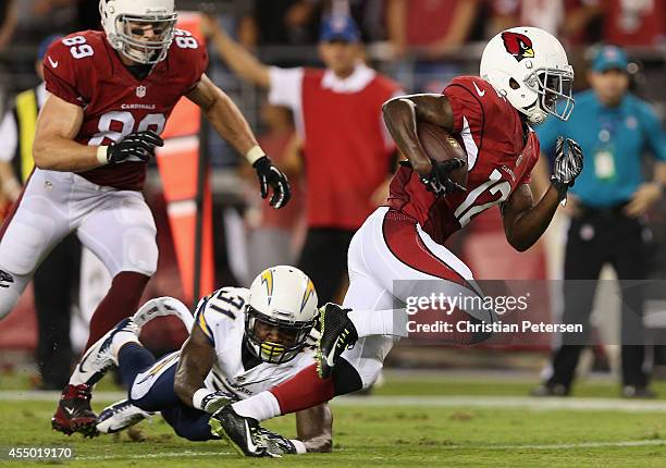 Wide receiver John Brown of the Arizona Cardinals runs with the football enroute to scoring a 13 yard rushing touchdown past cornerback Richard...