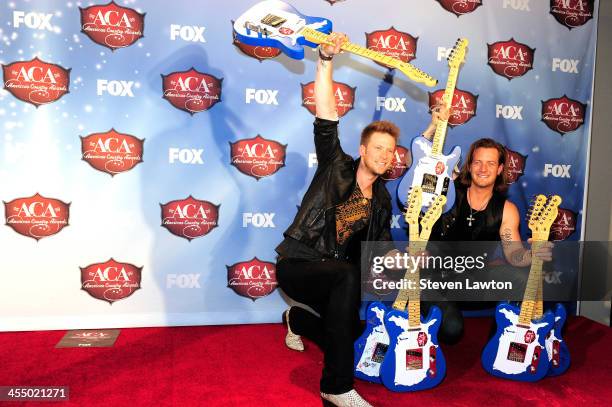 Recording artists Tyler Hubbard and Brian Kelly of Florida Georgia Line pose in th press room during the American Country Awards 2013 at the Mandalay...