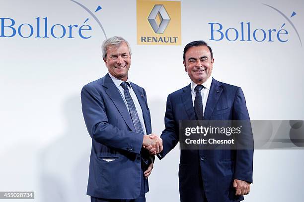 The CEO of French carmaker Renault, Carlos Ghosn , shakes hands with French industrial group Bollore's head Vincent Bollore at the end of a press...