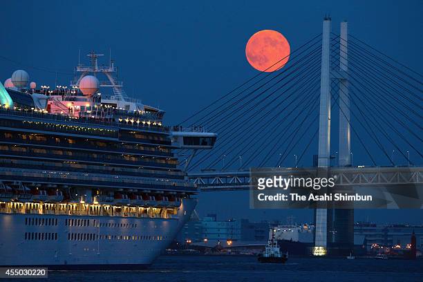 Cruise ship departs while a super moon rises over the Bay Bridge at the port of Yokohama on September 9, 2014 in Yokohama, Kanagawa, Japan.