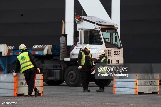Port workers inspect a container shipment at the Hanjin Shipping Co. Busan New Port terminal in Busan, South Korea, on Tuesday, Dec. 10, 2013. South...