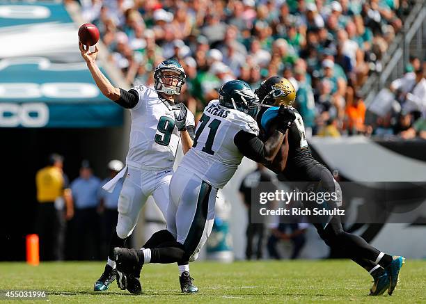 Quarterback Nick Foles of the Philadelphia Eagles gets off a pass as teammate Jason Peters blocks Chris Clemons of the Jacksonville Jaguars during...