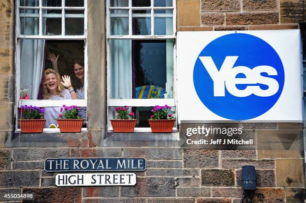 Two women wave from a window of a property on the Royal Mile on September 9, 2014 in Edinburgh,Scotland. With just eight days of campaigning left...