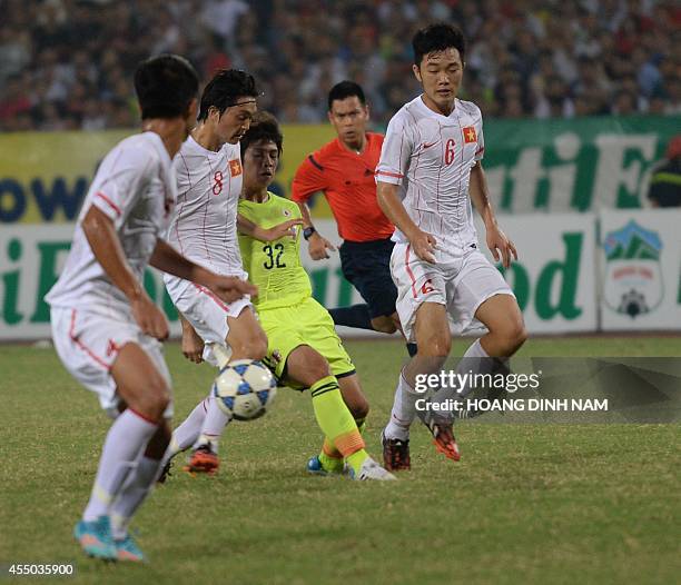 Japan's Sugimoto Taro fights for the ball with Vietnam's Nguyen Tuan Anh and Luong Xuan Truong during a match of the AFF Nutifood U19 Cup in Hanoi on...