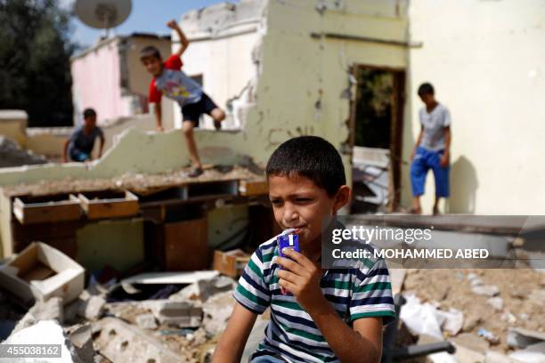 Palestinian children play near a destroyed house in Bureij refugee camp in the central Gaza Strip on September 9, 2014. The United Nations and the...