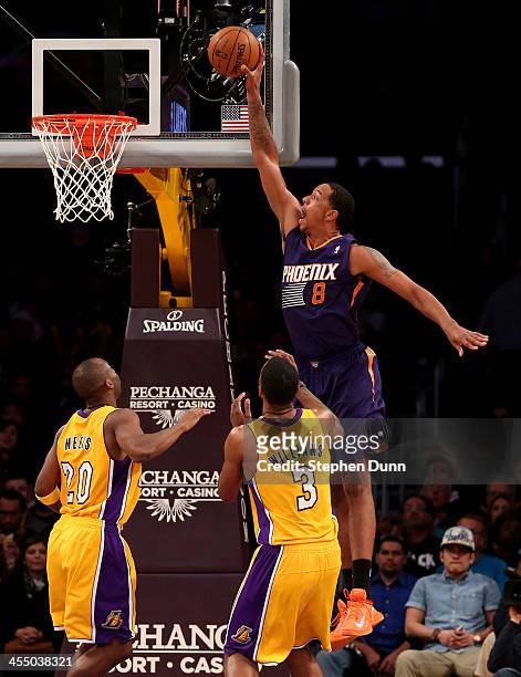 Channing Frye of the Phoenix Suns dunks over Shawne Williams and Jodie Meeks of the Los Angeles Lakers at Staples Center on December 10, 2013 in Los...
