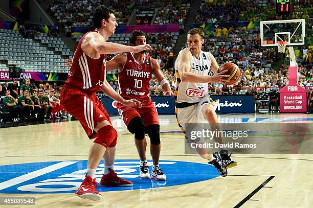 Martynas Pocius of the Lithuania Basketball Men's National Team runs towards the basket against Kerem Tunceri and Omer Asik of the Turkey Basketball...