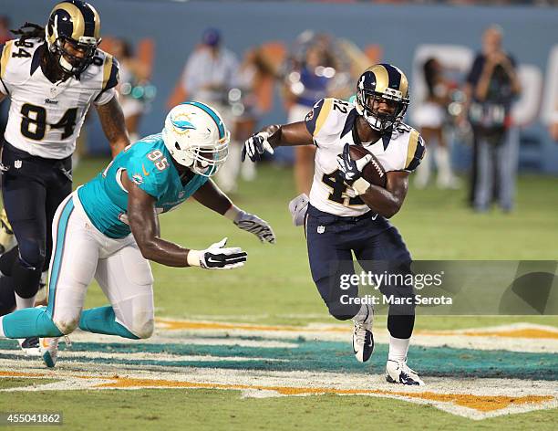 Dion Jordon of the Miami Dolphins plays against Trey Watts of the St. Louis Rams during a preseason game at Sun Life Stadium on August 28, 2014 in...