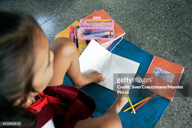 Cuban nine year old Daylin Valdes Chong, who was born without arms, uses her feet to write as she attends a class in the special needs school...