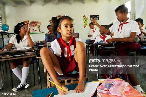 Cuban nine year old Daylin Valdes Chong, who was born without arms, uses her feet to write as she attends a class in the special needs school...