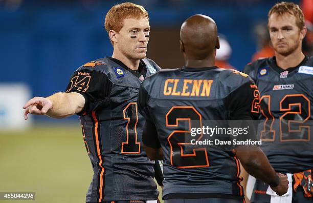 Travis Lulay, Kevin Glenn and John Beck all of the BC Lions talk together as they face the Toronto Argonauts during their game at Rogers Centre on...