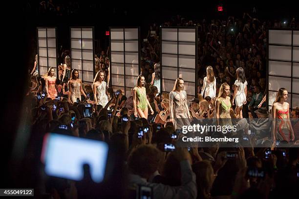 Audience members use smartphones and cameras to photograph the Herve Leger by Max Azria fashion show during Mercedes-Benz Fashion Week Spring 2015 at...