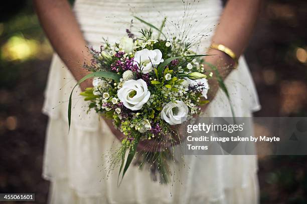 bride holding wedding bouque - bouquet stockfoto's en -beelden