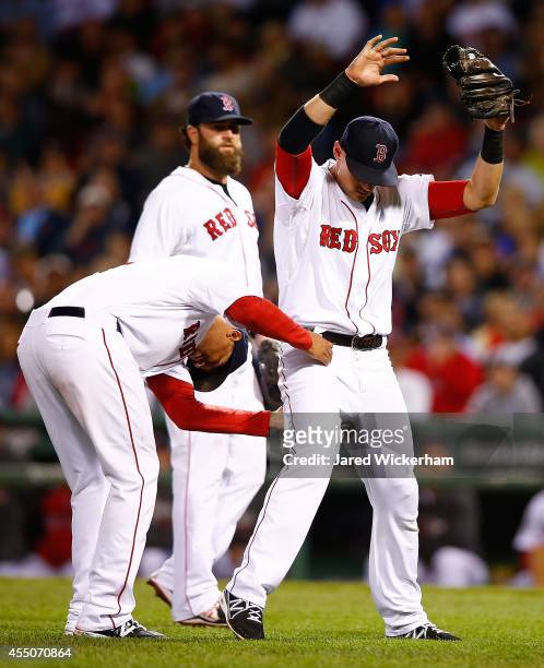 Will Middlebrooks of the Boston Red Sox is grabbed by the waist by teammate Xander Bogaerts after catching a fly ball in the infield against the...