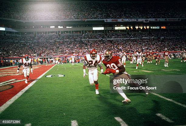 Jerry Rice of the San Francisco 49ers runs with the ball towards the end zone while pursued by Lewis Billups of the Cincinnati Bengals during Super...