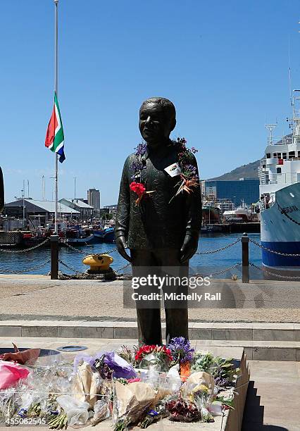 Flowers adorn a statue of late South African President Nelson Mandela at the V&A Waterfront on December 10, 2013 in Cape Town, South Africa. Over 60...