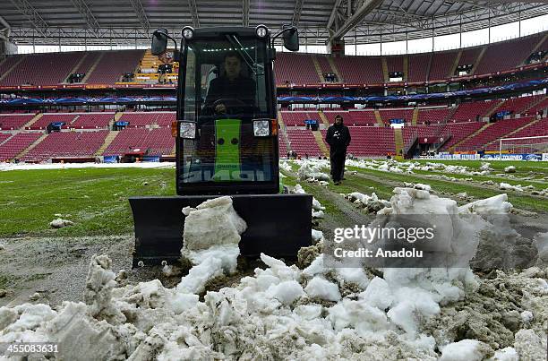 Workers clean the pitch from snow on December 11, 2013 as the UEFA Champions League group B soccer match between Galatasaray and Juventus was...