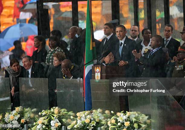 Man motions with his hands as Cuban President Raul Castro, Brazilian President Dilma Rousseff and Andrew Mlangeni listen as United States President...