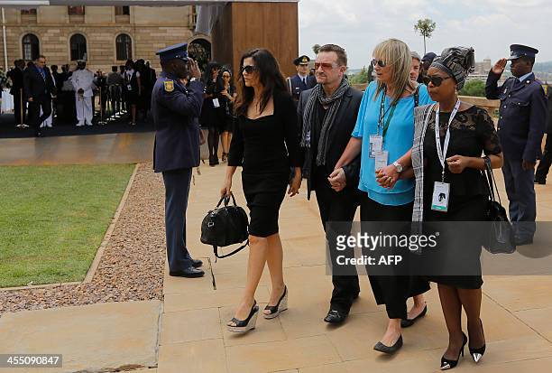 Bono and his wife, Alison Hewson and Nelson Mandela's former assistant, Zelda le Grange leave after seeing the coffin of former South African...
