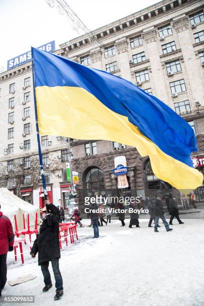 Protester waving a huge flag of Ukraine near Independence Square on December 11, 2013 in Kiev, Ukraine. Riot police today tried to break into City...