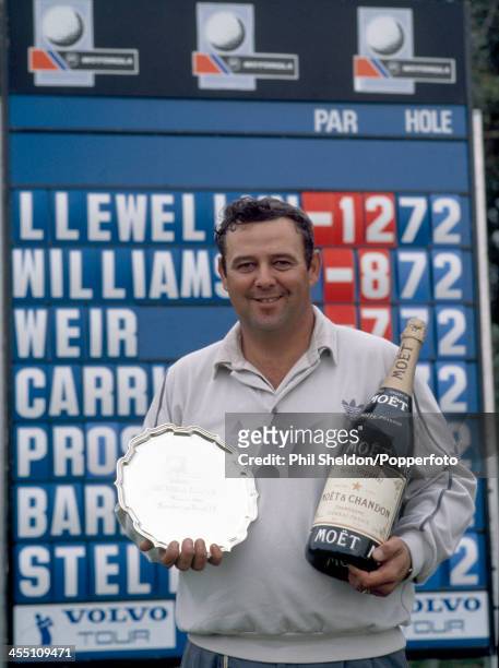 David Llewellyn of Great Britain with the trophy and a bottle of Champagne after winning the Motorola Classic Golf Tournament held at the Burnham and...