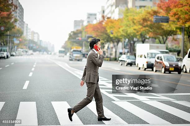 business man using the smartphone in the city - crossing street stock pictures, royalty-free photos & images