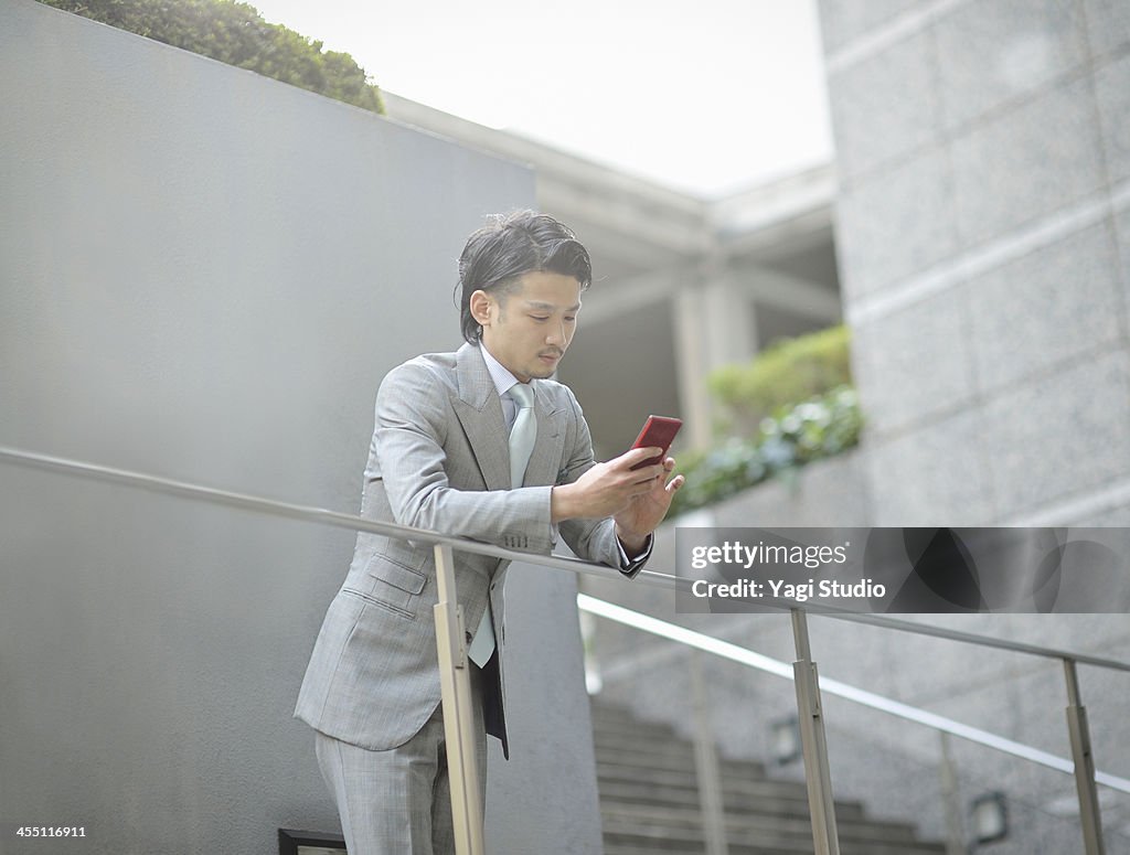 Business man using smartphone in buildings