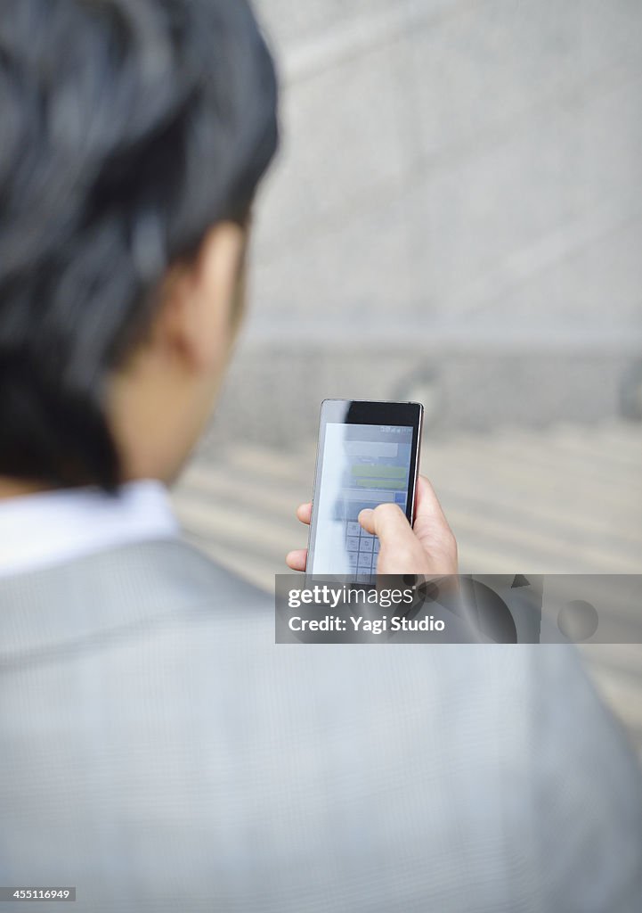 Business man using smartphone in buildings