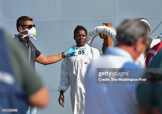 An African migrant woman is photographed with an identification number after disembarking from the Italian Navy ship Foscari on August 23, 2014 in...