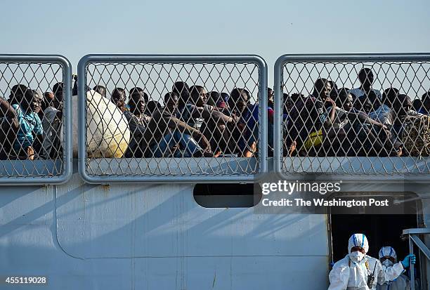 African migrants wait to disembark from the Italian Navy ship Foscari on August 23, 2014 in Portopalo di Capo Passero, Italy. The migrants were...