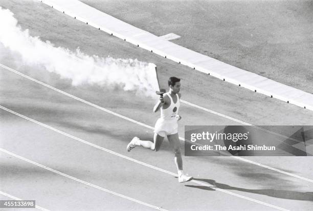 Tokyo Olympic final torch runner Yoshinori Sakai runs during the opening ceremony of the 1964 Tokyo Olympics at the national stadium on October 10,...
