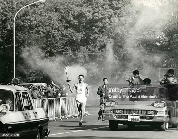 Tokyo Olympic final torch runner Yoshinori Sakai runs during the opening ceremony of the 1964 Tokyo Olympics on October 10, 1964 in Tokyo, Japan....