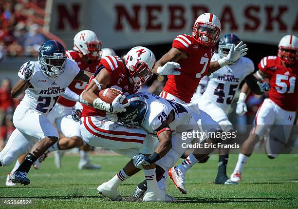 Defensive back Sharrod Neasman of the Florida Atlantic Owls wraps up wide receiver Kenny Bell of the Nebraska Cornhuskers during their game at...