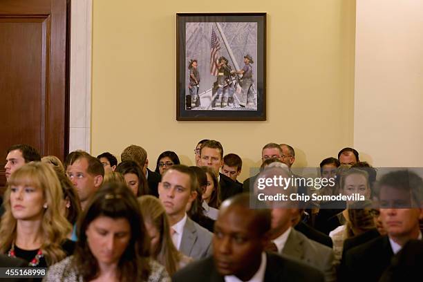 Photograph of firefighters raising a flag at Ground Zero on 9/11 hangs on the wall during a hearing of the House Homeland Security Committee's Border...