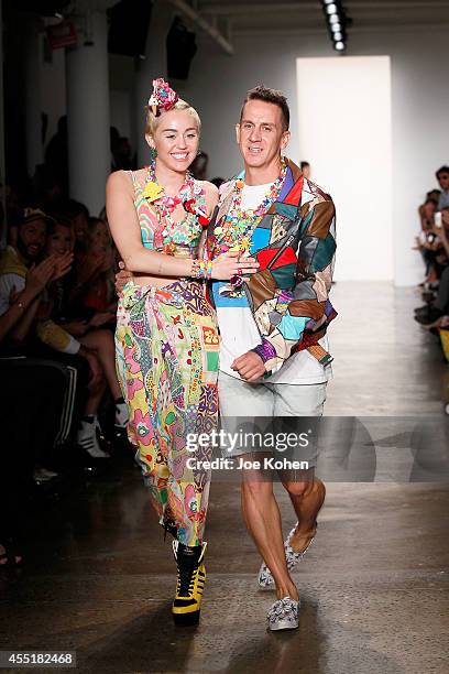 Miley Cyrus and designer Jeremy Scott walk the runway at the Jeremy Scott fashion show during MADE Fashion Week Spring 2015 at Milk Studios on...