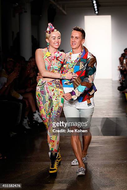 Miley Cyrus and designer Jeremy Scott walk the runway at the Jeremy Scott fashion show during MADE Fashion Week Spring 2015 at Milk Studios on...