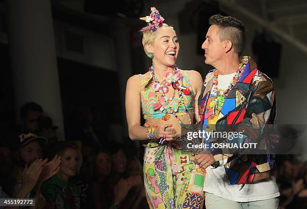 Pop star Miley Cyrus and designer Jeremy Scott walk the runway during his Spring/Summer 2015 collection at York Fashion Week September 10, 2014 in...