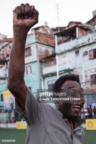 Legendary Brazilian former football player Pele raises his fist during the inauguration ceremony of the new technology football pitch installed at...