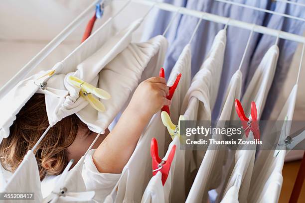 small boy helping with laundry - wäscheklammer stock-fotos und bilder