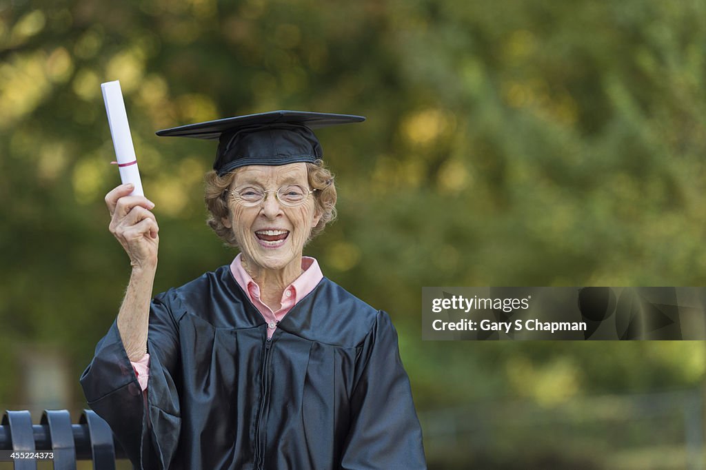 Elderly woman graduate with diploma