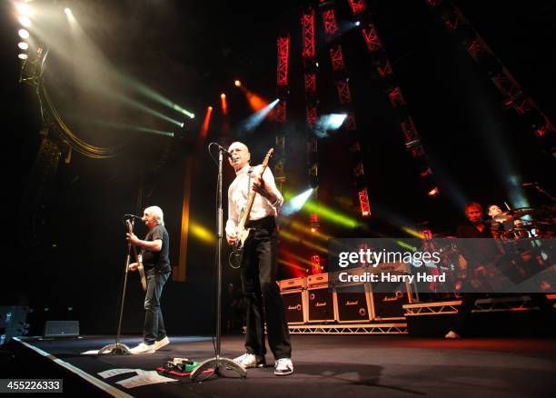 Rick Parfitt, Francis Rossi, John 'Rhino' Edwards and Leon Cave of Status Quo perform on stage at BIC on December 11, 2013 in Bournemouth, United...